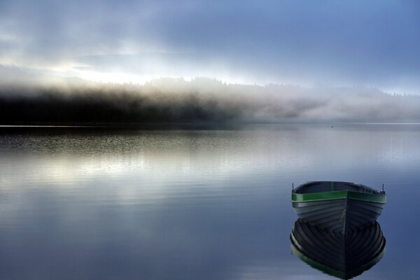 Ein Boot auf dem See. Morgennebel