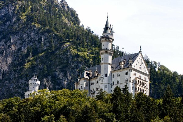 Bayerisches Schloss in den Bergen mit weißem Turm