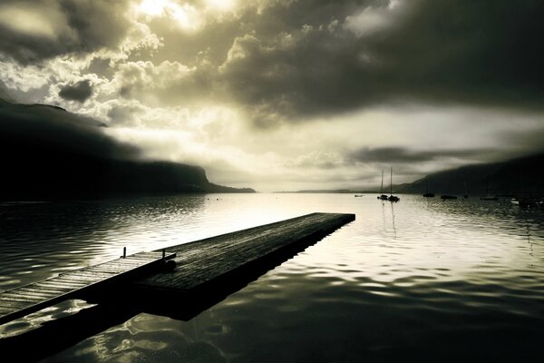 Dark pier on the lake shore