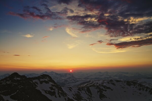 Puesta de sol en las montañas cubiertas de nieve