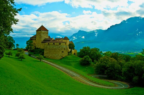 An old castle in the mountains with a road