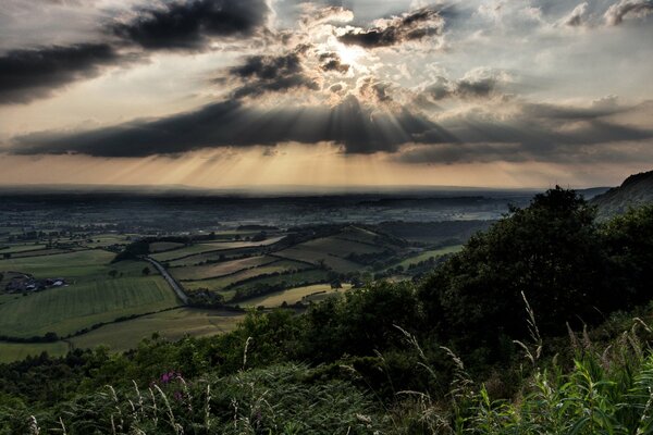 Rays of light illuminate a green valley