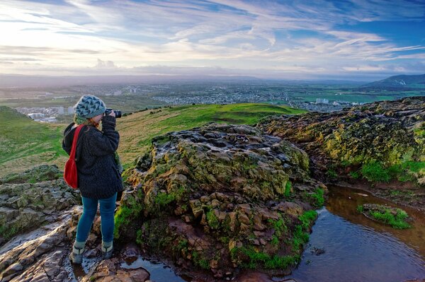 A girl takes pictures of nature in the hills