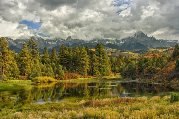 Lago cerca del bosque y las montañas en otoño