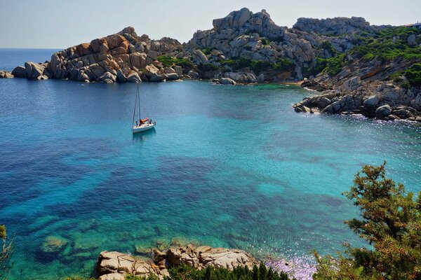 Yacht in the bay by the rocks in Italy