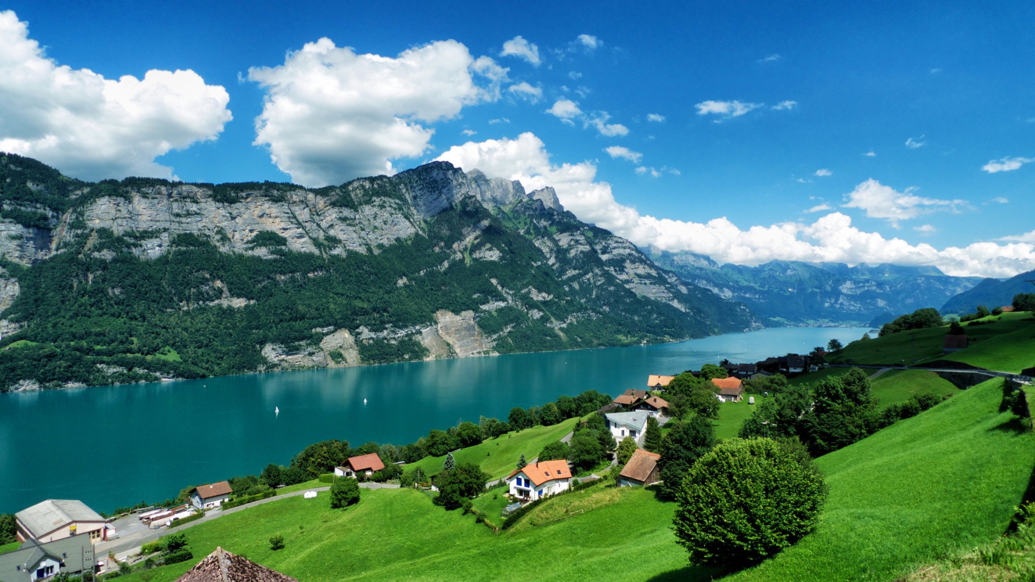 cielo montagne nuvole foresta alberi erba lago case strada ponte