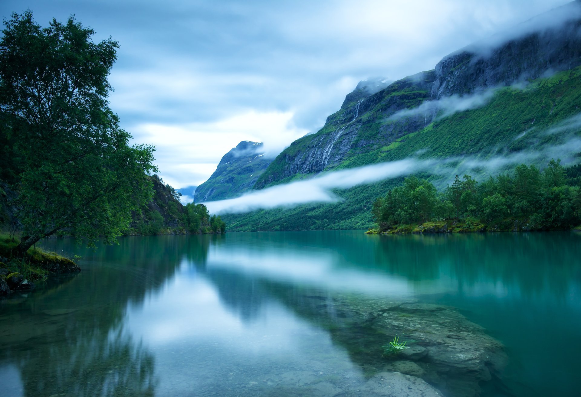 western norway loenvatnet lake loen surface of the bottom stones nordic mountain tree fog sky cloud