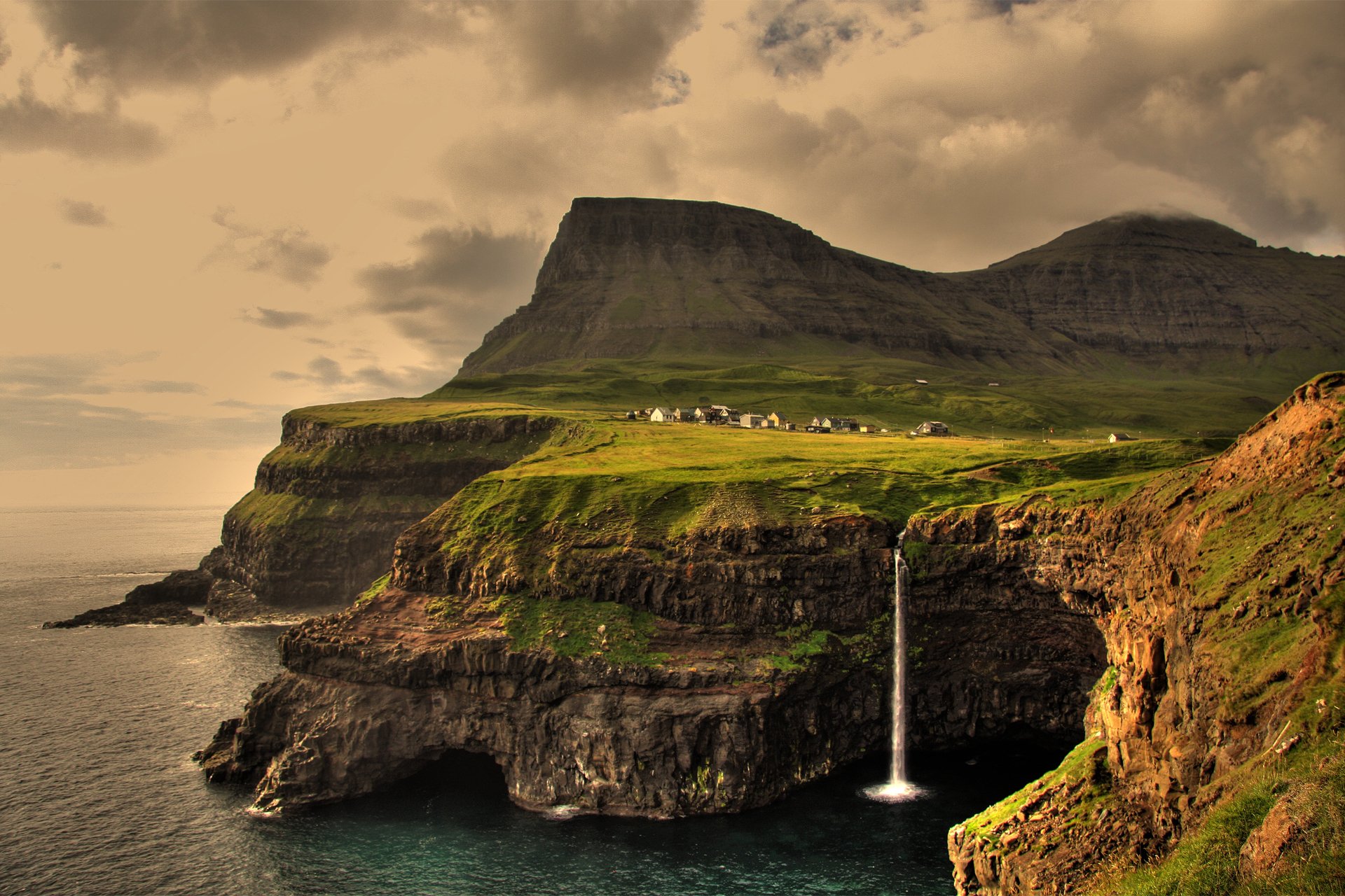 islas feroe vága gásadalur océano atlántico acantilados en el borde pueblo montañas cascada puesta de sol cielo nubes