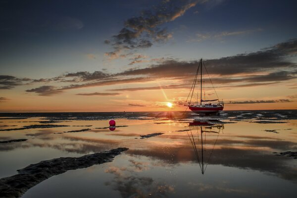 Bateau dans la mer sur fond de coucher de soleil