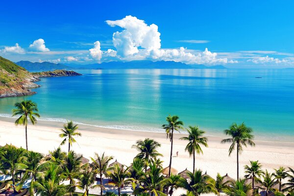 La mer se confond avec les nuages et à côté de la plage tropicale