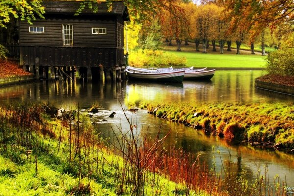 Una cabaña y dos botes. Fotografía de otoño