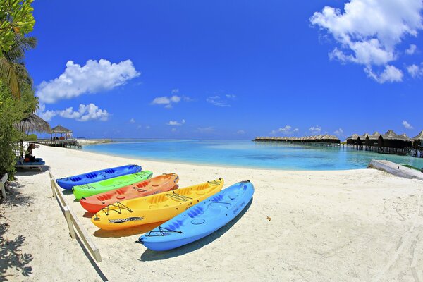 Playa de arena con barcos de colores