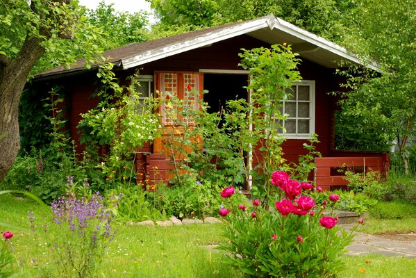 Maison d été sur fond de fleurs et d arbres verdoyants