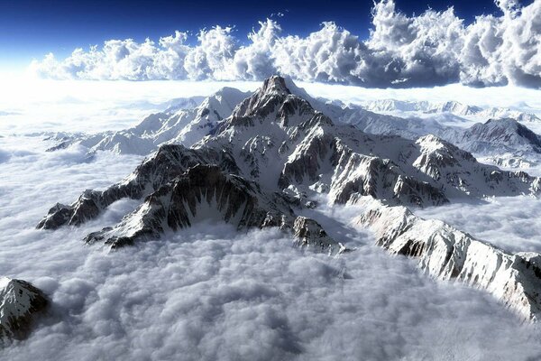 Cime di montagna nella neve e nuvole