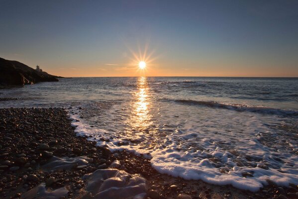 Schiuma di mare con il sole al tramonto