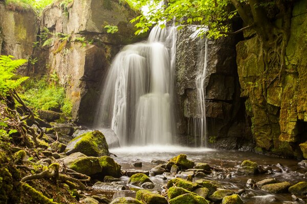 Rocía una cascada de montaña sobre las rocas