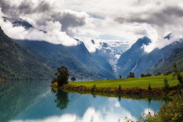 Nubes en las montañas sobre un Prado verde en Noruega