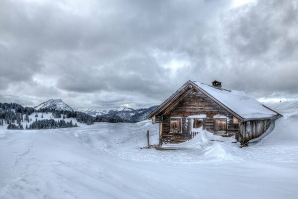 Holzhaus in den schneebedeckten Bergen