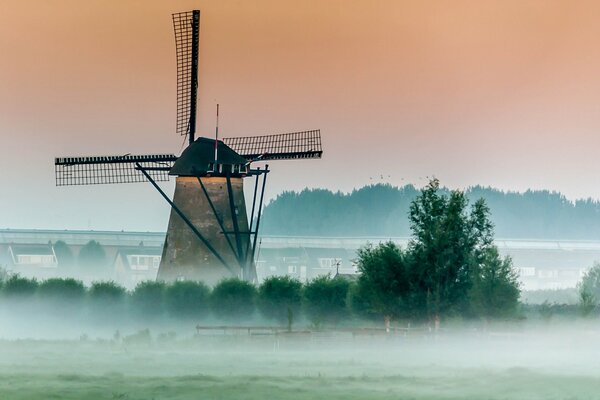 A windmill in a foggy morning