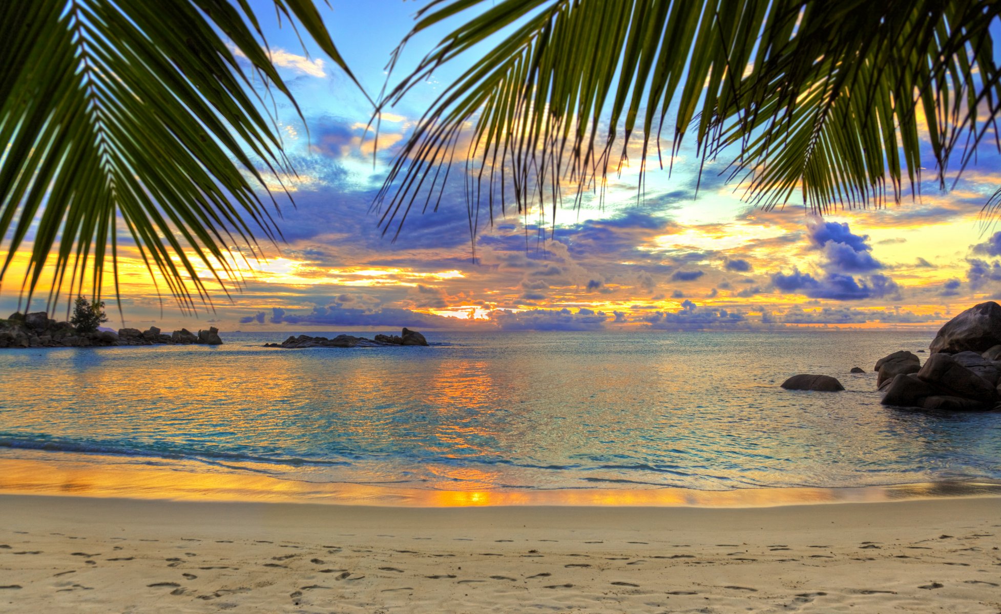 sabbia spiaggia impronte mare palme rocce cielo nuvole tramonto