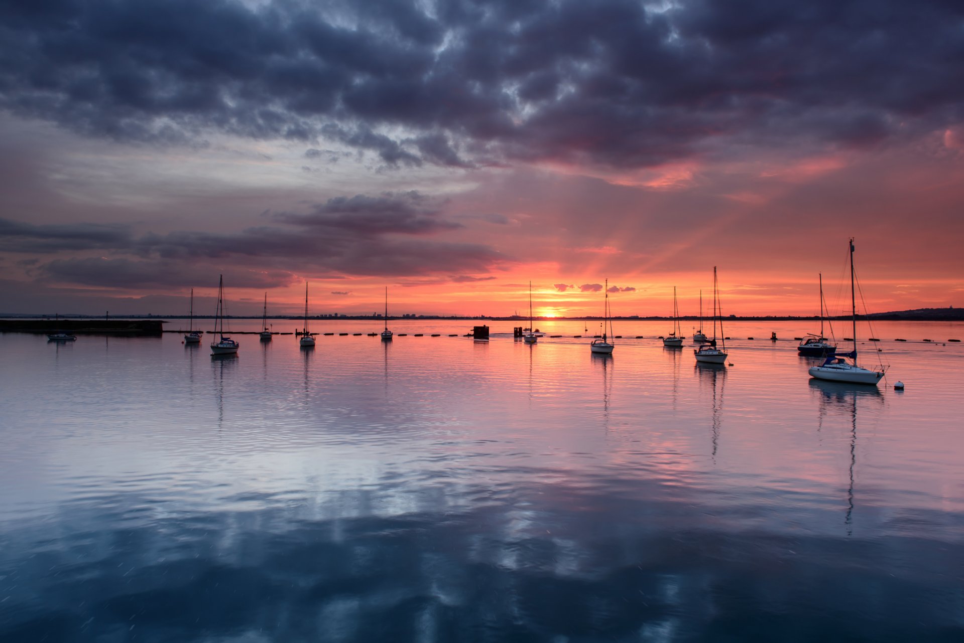 reino unido inglaterra hampshire condado bahía calma yates tarde naranja puesta de sol horizonte azul gris cielo nubes reflexión