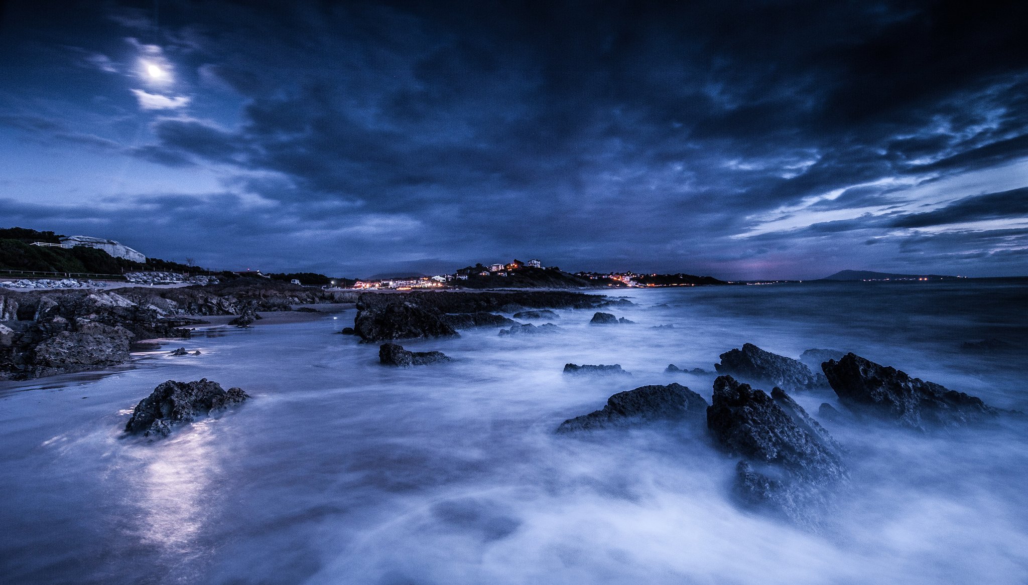 mare notte luna nuvole pietre riva luci