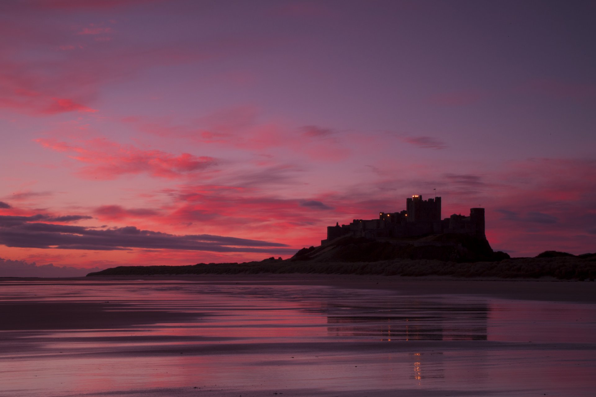 wielka brytania anglia bamburgh castle zamek bamburgh morze brzeg wieczór szkarłat zachód słońca niebo chmury krajobraz