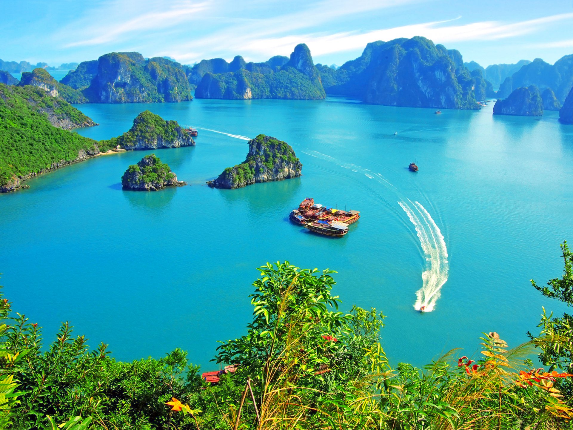 vietnam baie d halong falaises îles végétation bateaux de plaisance yachts jonques ciel nuages