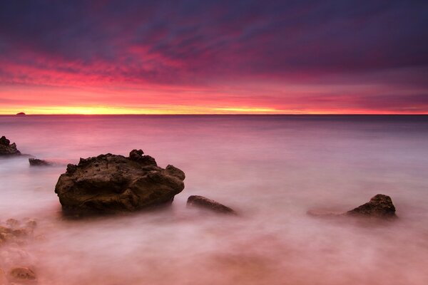 Pietre sul mare. Cielo rosa