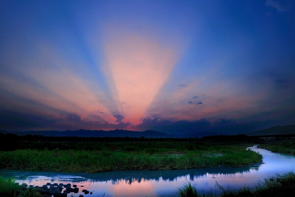 Pink clouds on the background of the blue surface of the riverbed