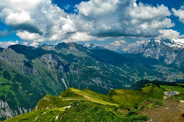 Image of bright green mountains against the sky with clouds