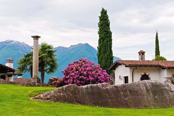 Paysage de montagne avec des colonnes et des palmiers sur fond de maison