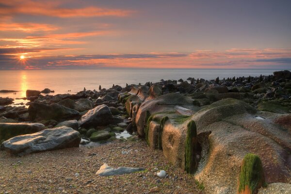 Grandes piedras en la playa con el amanecer