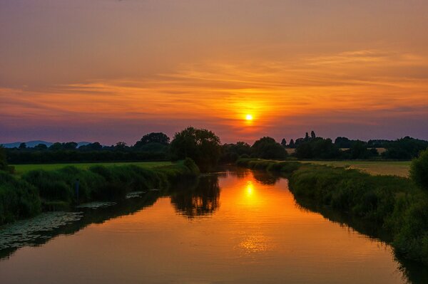 El río fluye bajo el sol del atardecer