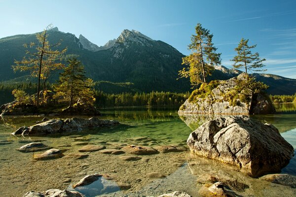 Vista de un lago poco profundo con vistas a las montañas en el parque nacional Berchtesgaden