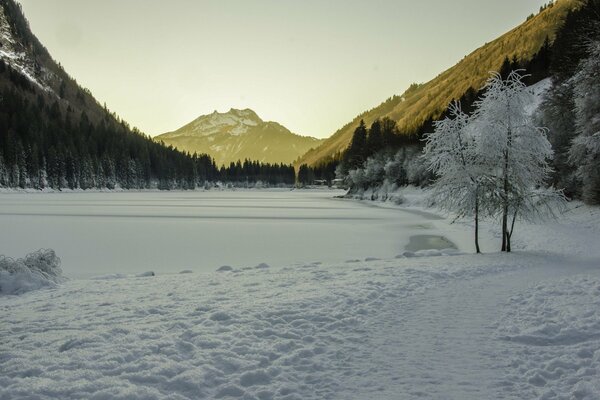 Invierno. Lago bajo el hielo en medio de las montañas