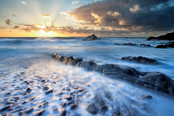 Amanecer y niebla que cubre el agua rocas y piedras