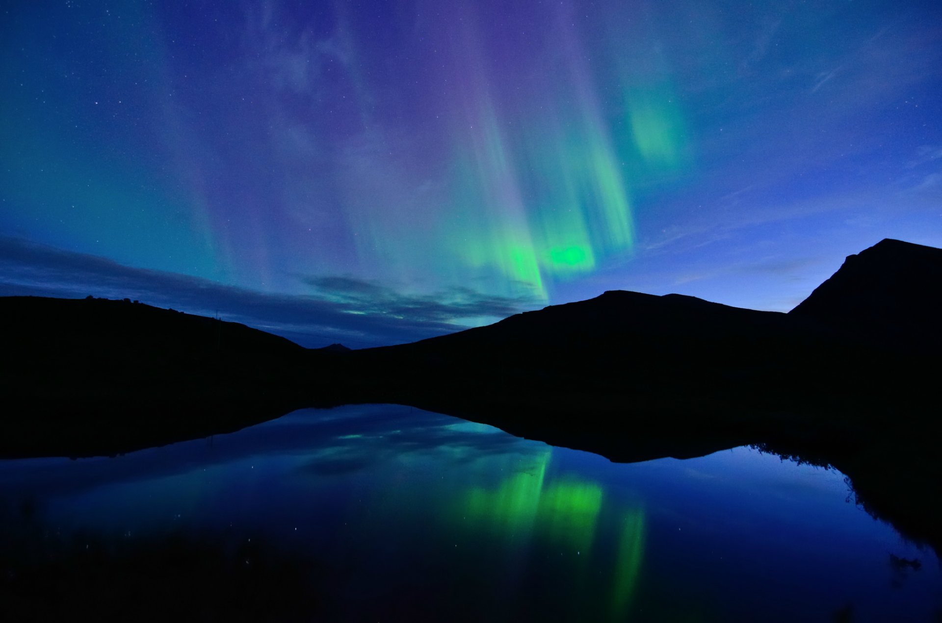 norvegia notte nord aurora boreale blu cielo nuvole lago acqua superficie liscia riflessione