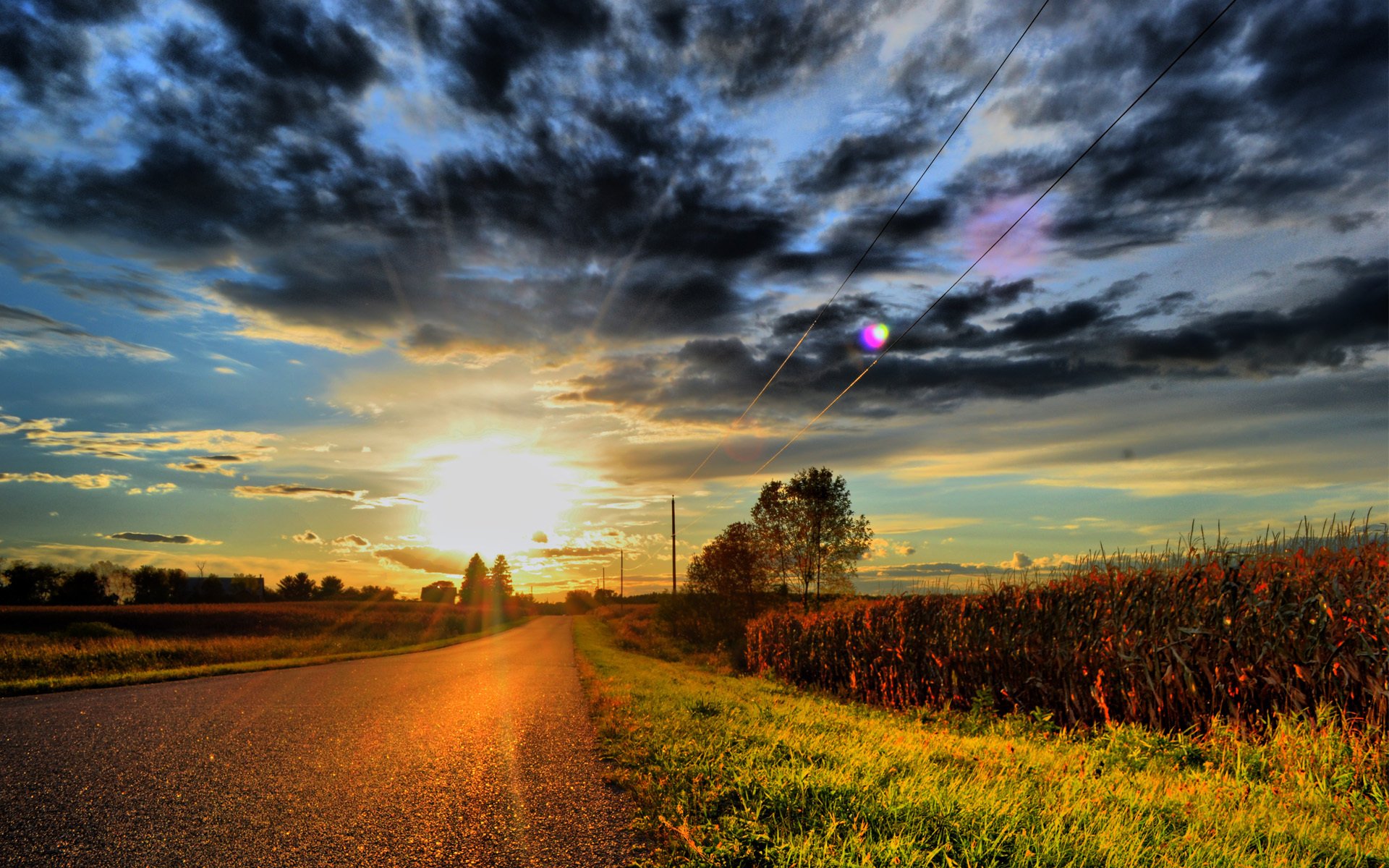 road clouds clouds sun sunset grass power line