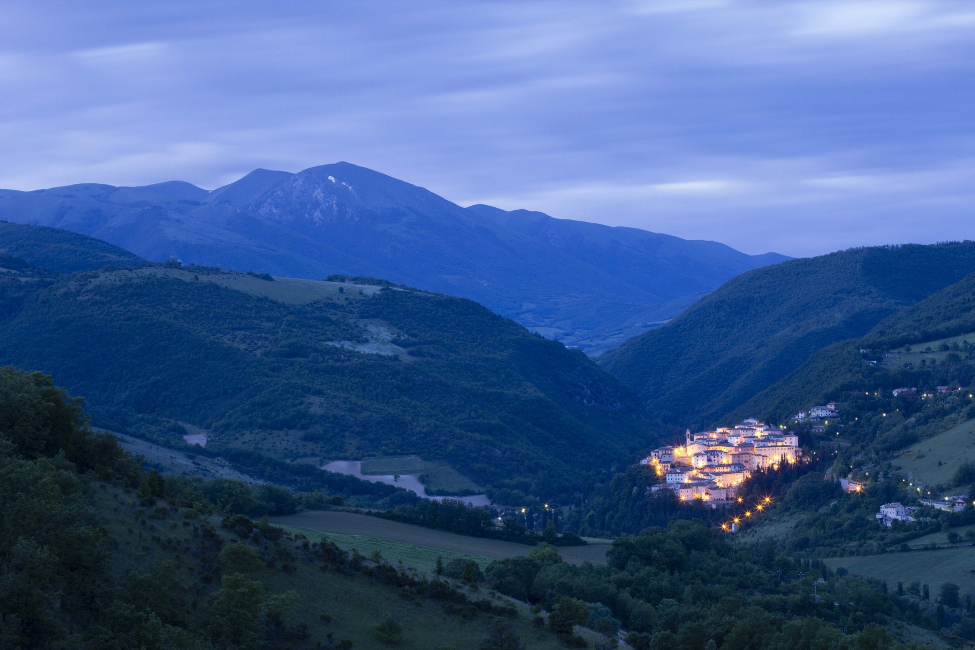 włochy umbria osada domy światła oświetlenie przed świtem góry drzewa natura panorama niebo chmury