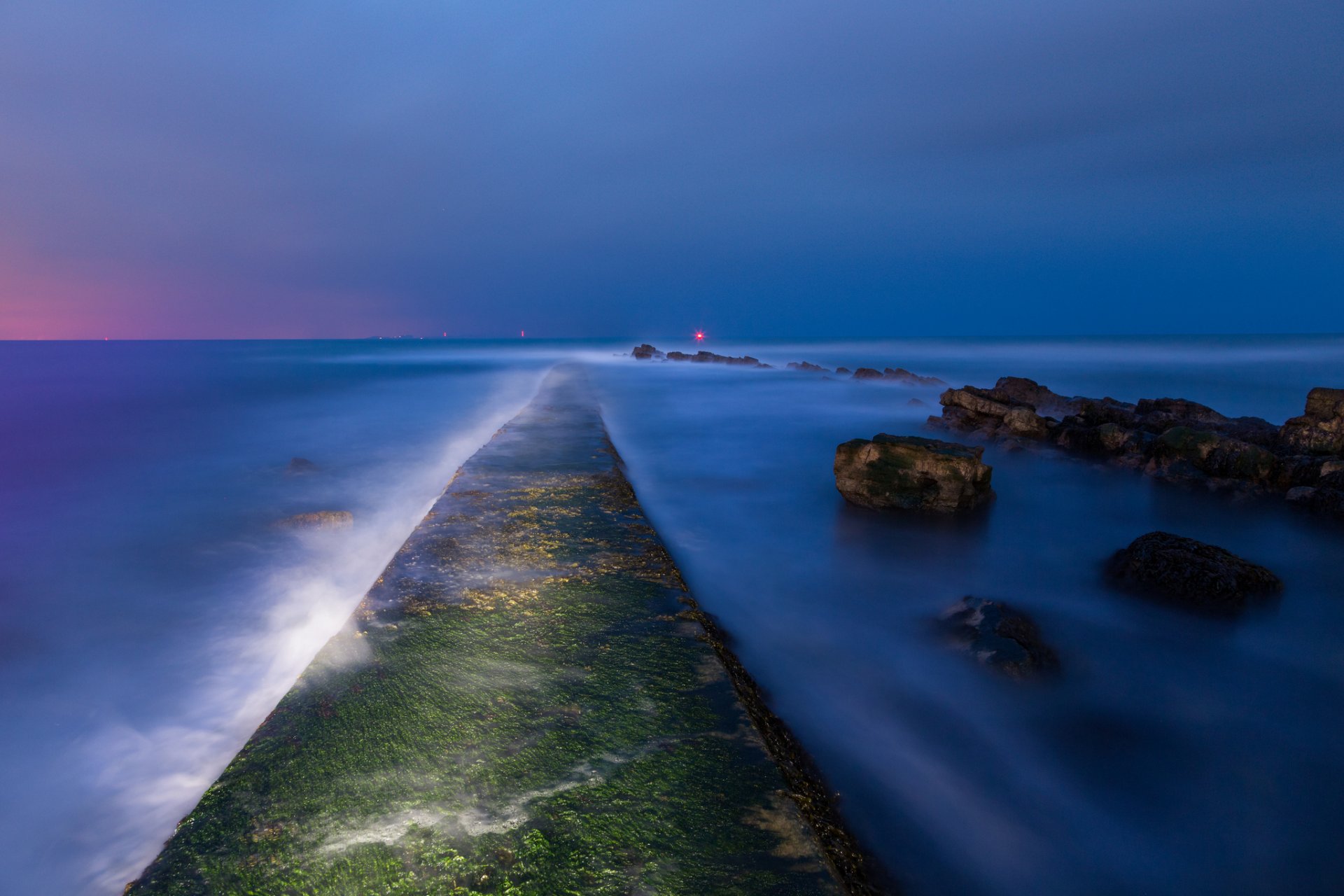 reino unido inglaterra tarde anochecer bahía mar costa piedras musgo luces lejos cielo azul