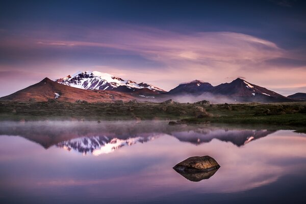 Iceland s evening mountains reflected in the lake