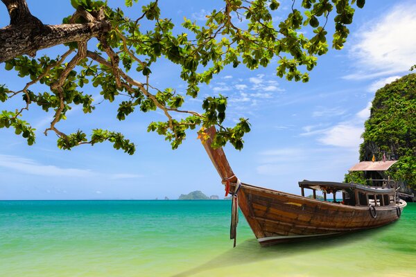 Un barco de madera se encuentra en la bahía de Tailandia