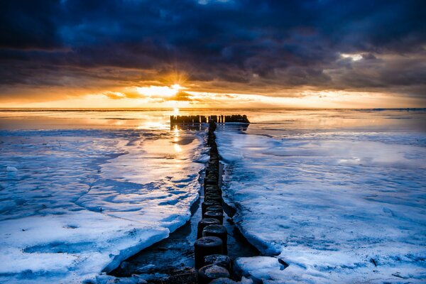 Piles dans la mer au coucher du soleil enchanteur