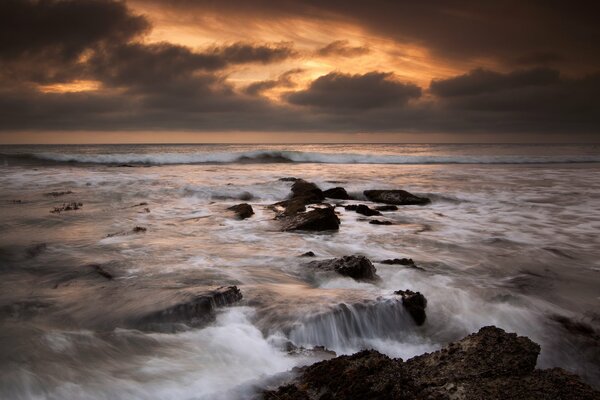 El agua del océano golpea las rocas