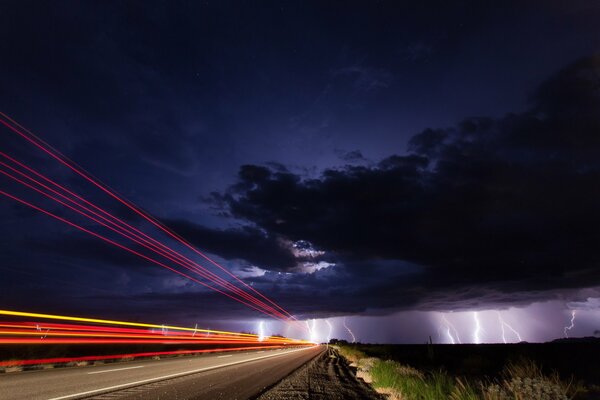 On the night sky through the clouds the light of lightning