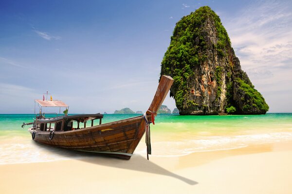 Boat on the shore against the background of a cliff