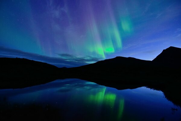 Aurores boréales dans le reflet d un lac en Norvège