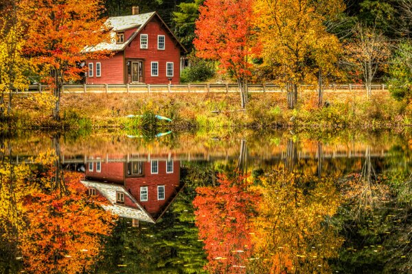 Autumn landscape with a house by the lake