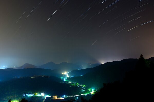 Hills at night over which a starfall